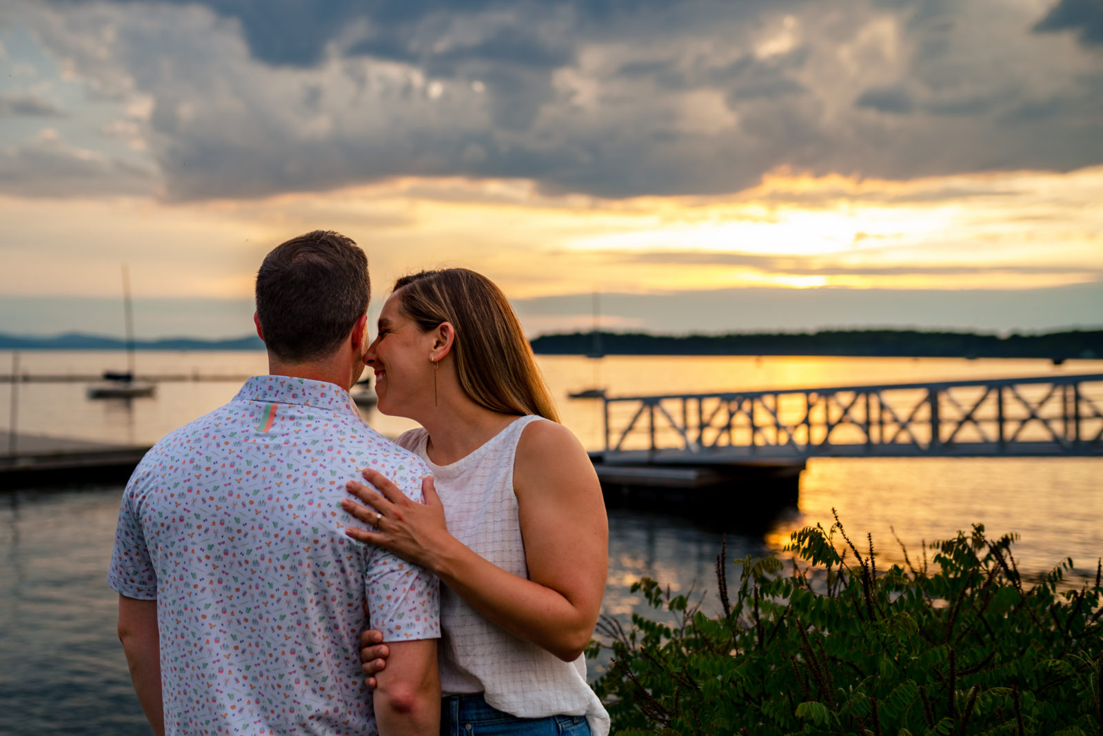 couple looking at sunset over lake champlain in burlington vermont by andy madea